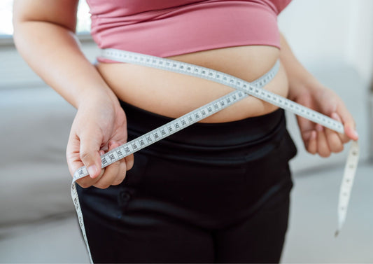 Person measuring waist for weight management, supported by Healthy Meals in Kolkata.
