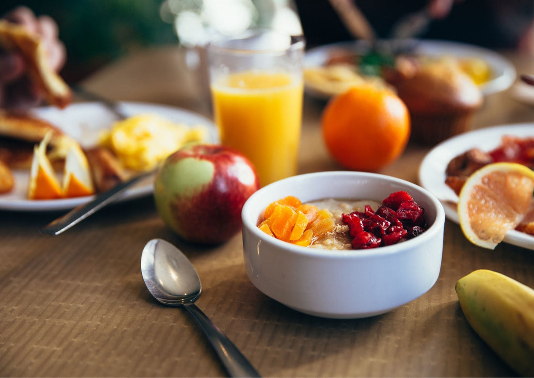 Healthy breakfast ideas for weight loss featuring oatmeal with dried fruits, fresh apples, oranges, and orange juice for a nutritious start.